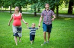 stock-photo-42192742-young-couple-in-park-playing-with-son-woman-is-pregnant